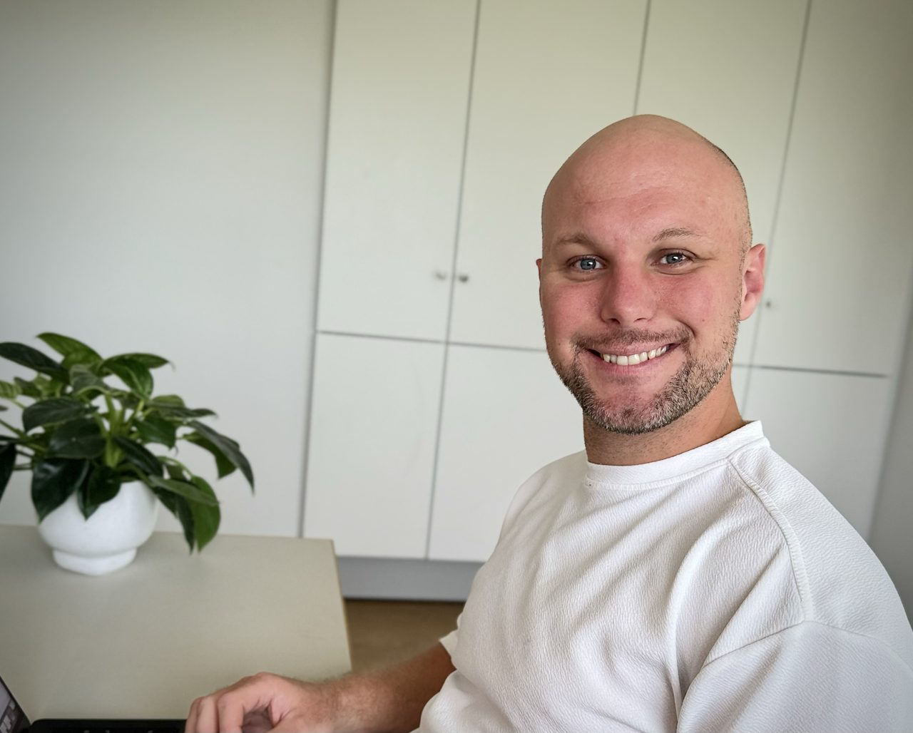 Rasmus Kruse ved skrivebordet med hånden på en bærbar computer